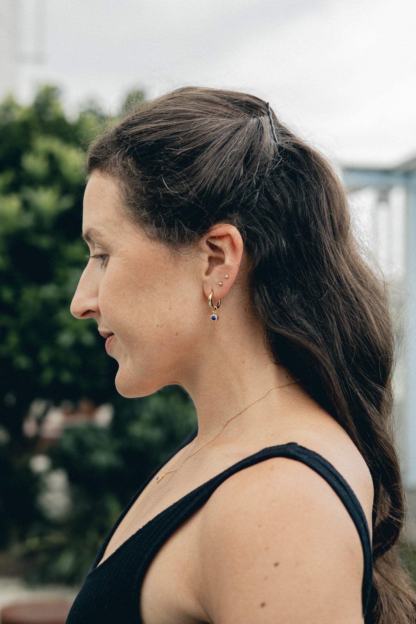 Lifestyle Shot - Model profile view, wearing Lapis Lazuli drop earring and necklace.