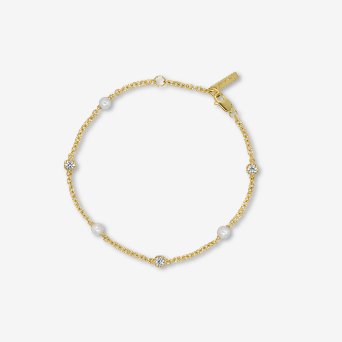 Gold bracelet with small pearls and topaz on a white background