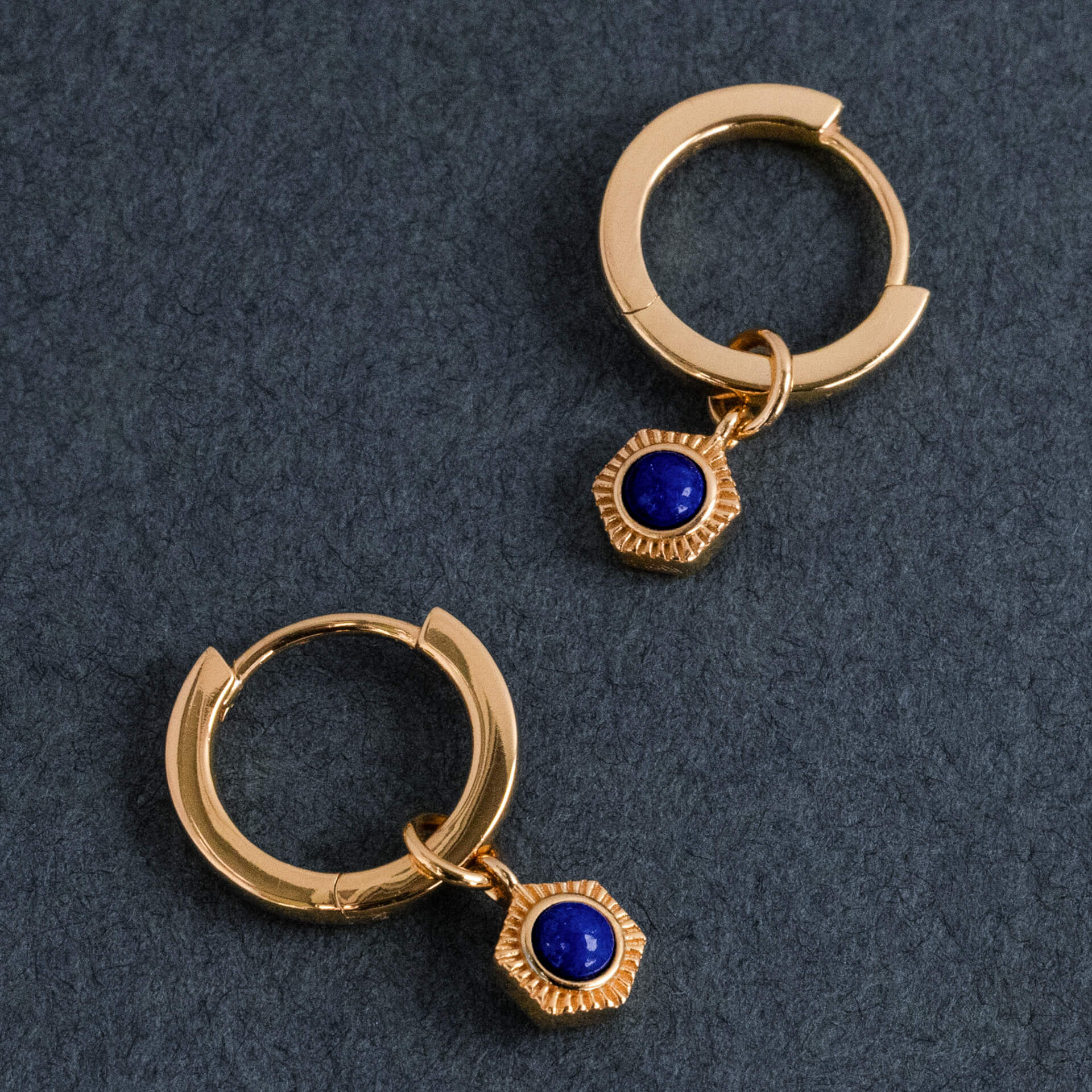 Earrings - Close-up of the Gold Lapis Lazuli pendant with Honeycomb/Hexagonal motif on a dark background.