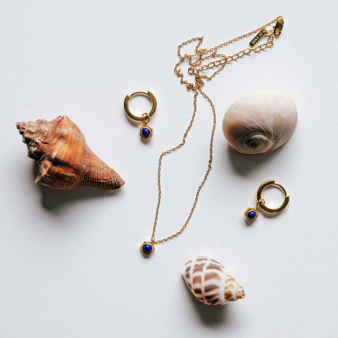 Full Set - Gold necklace and two huggie hoop earrings with Lapis Lazuli/blue stones, styled with natural seashells.