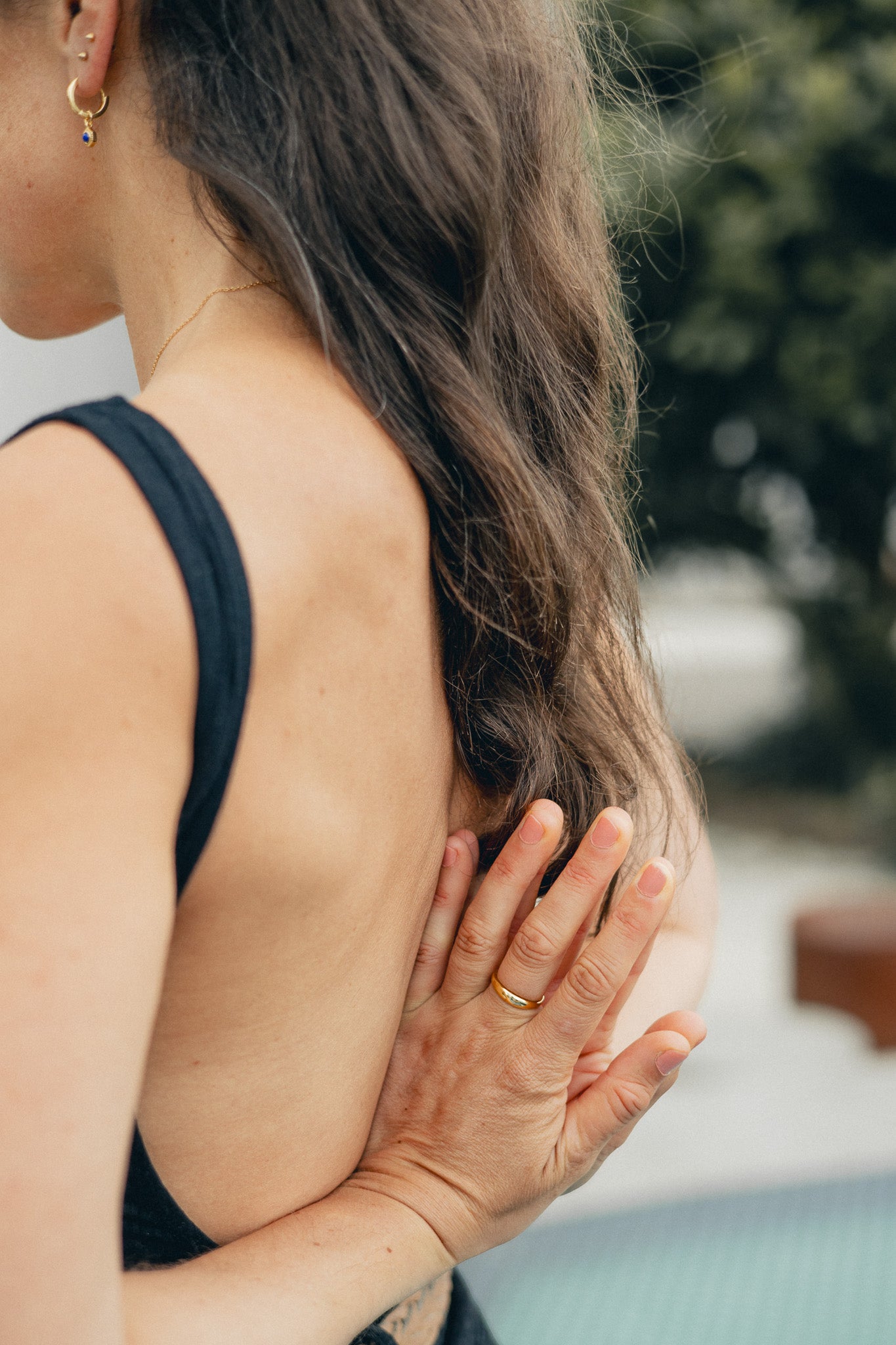 Lifestyle Shot - Close-up of model's back/hands, wearing Bel e Viv earring/necklace and Heritage dome ring in a yoga pose.