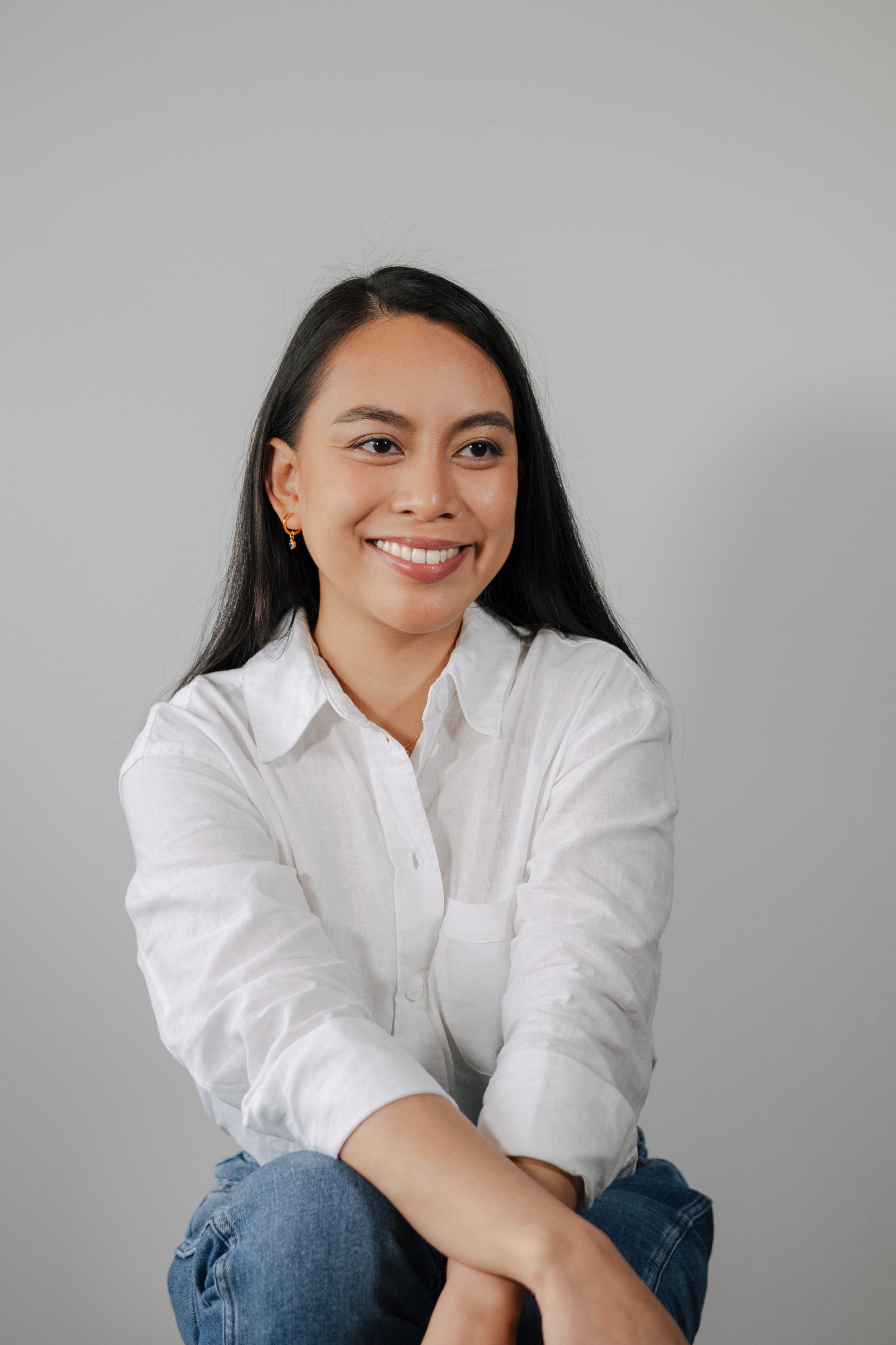 Portrait of Mia Tonin, co-founder of BY TONIN, smiling warmly with natural light highlighting her face, wearing simple jewellery.