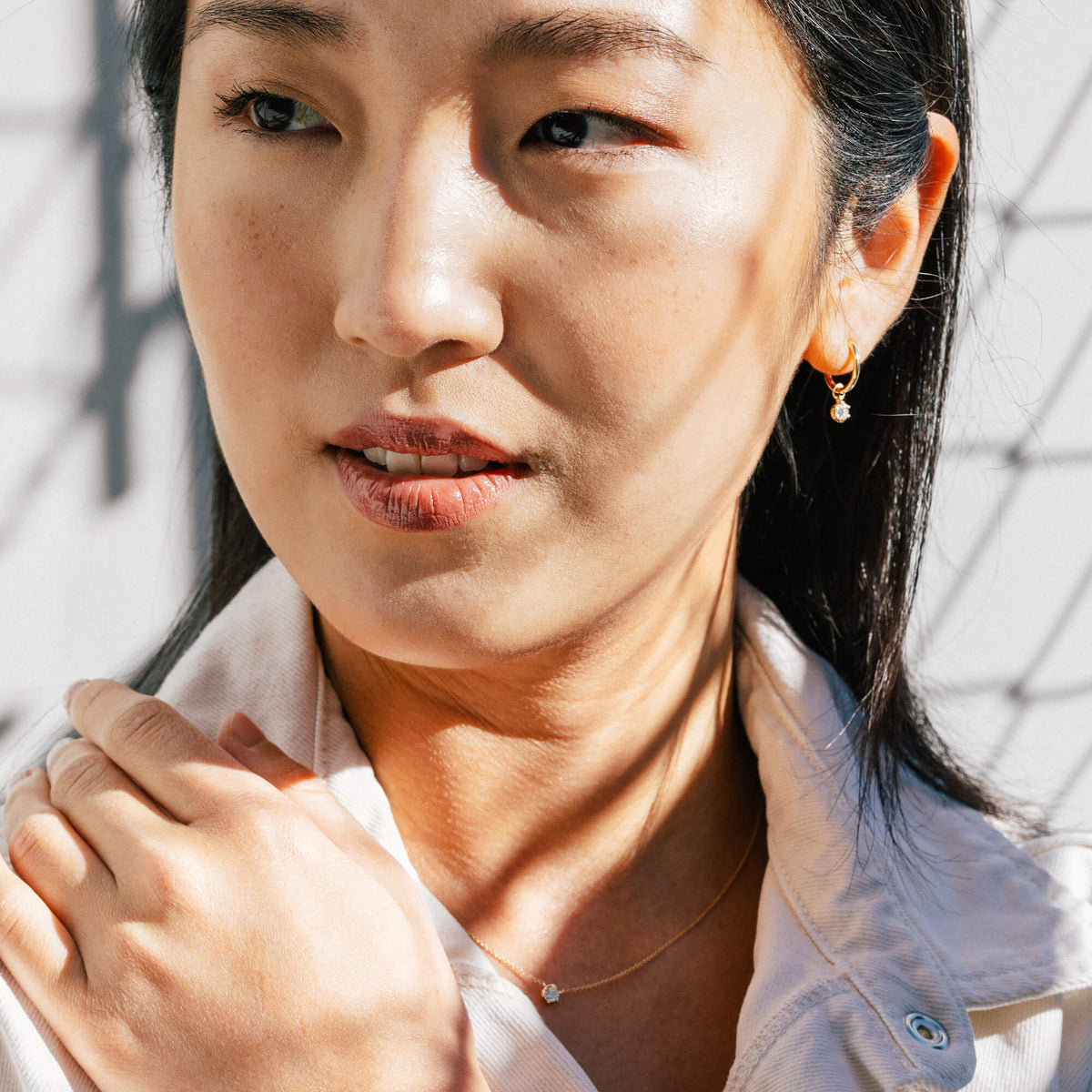Lifestyle portrait of model Hye Won Jang wearing the 9K gold diamond drop hoop earrings paired with the matching delicate chain necklace from the Essential Diamond Collection by BY TONIN, showcasing coordinated everyday jewellery styling.