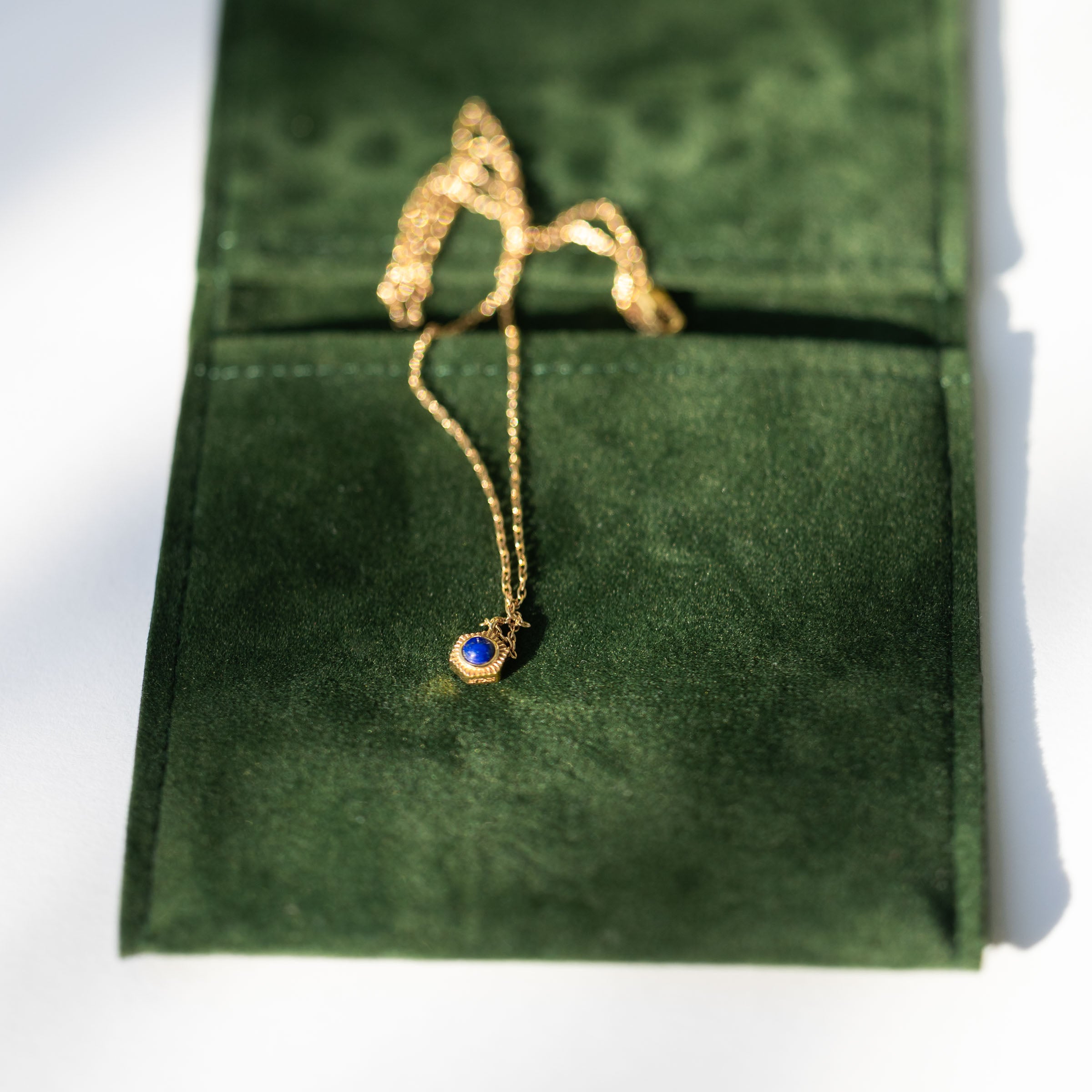 Unbox elegance with BY TONIN's Bel e Viv gold necklace, exquisitely featuring a vibrant round lapis lazuli pendant, beautifully presented on BY TONIN's luxurious green velvet branded packaging.