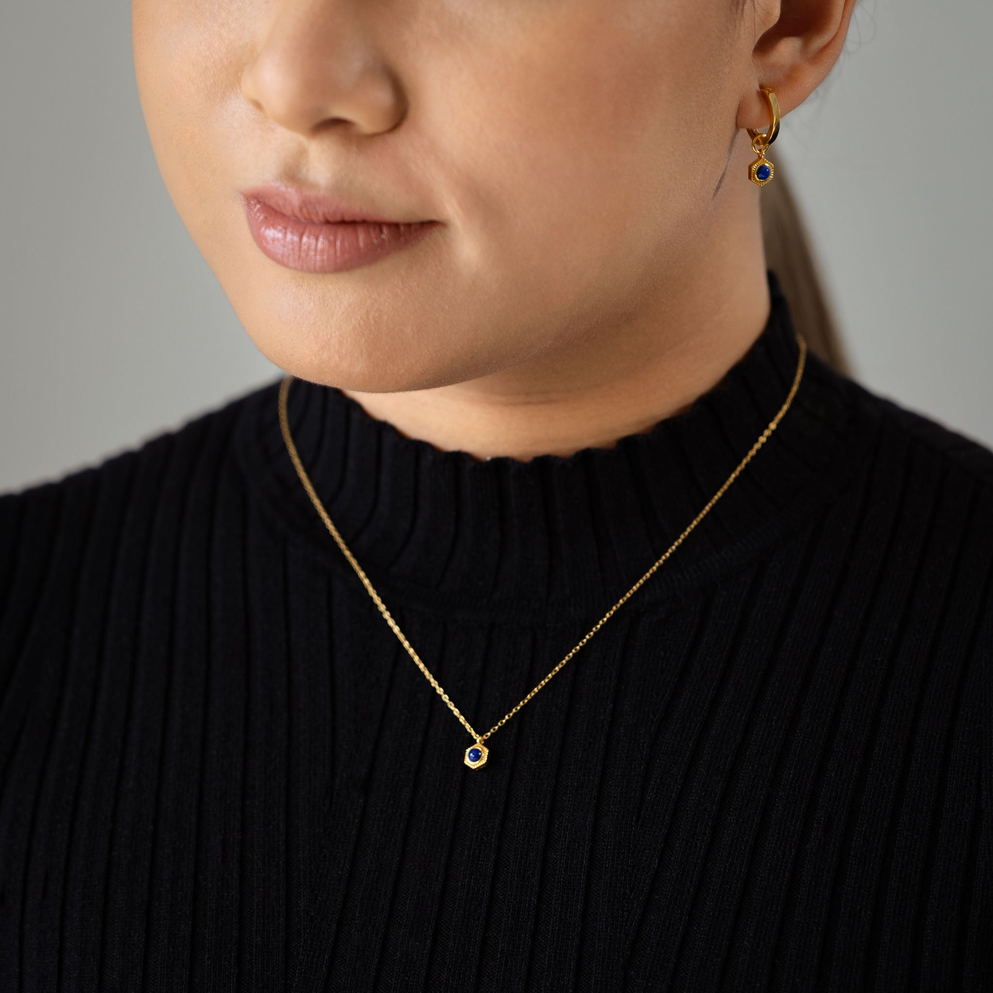 Adorn your neckline with BY TONIN's Bel e Viv gold necklace, gracefully showcasing a captivating honeycomb lapis lazuli pendant as worn in a stunning close-up.