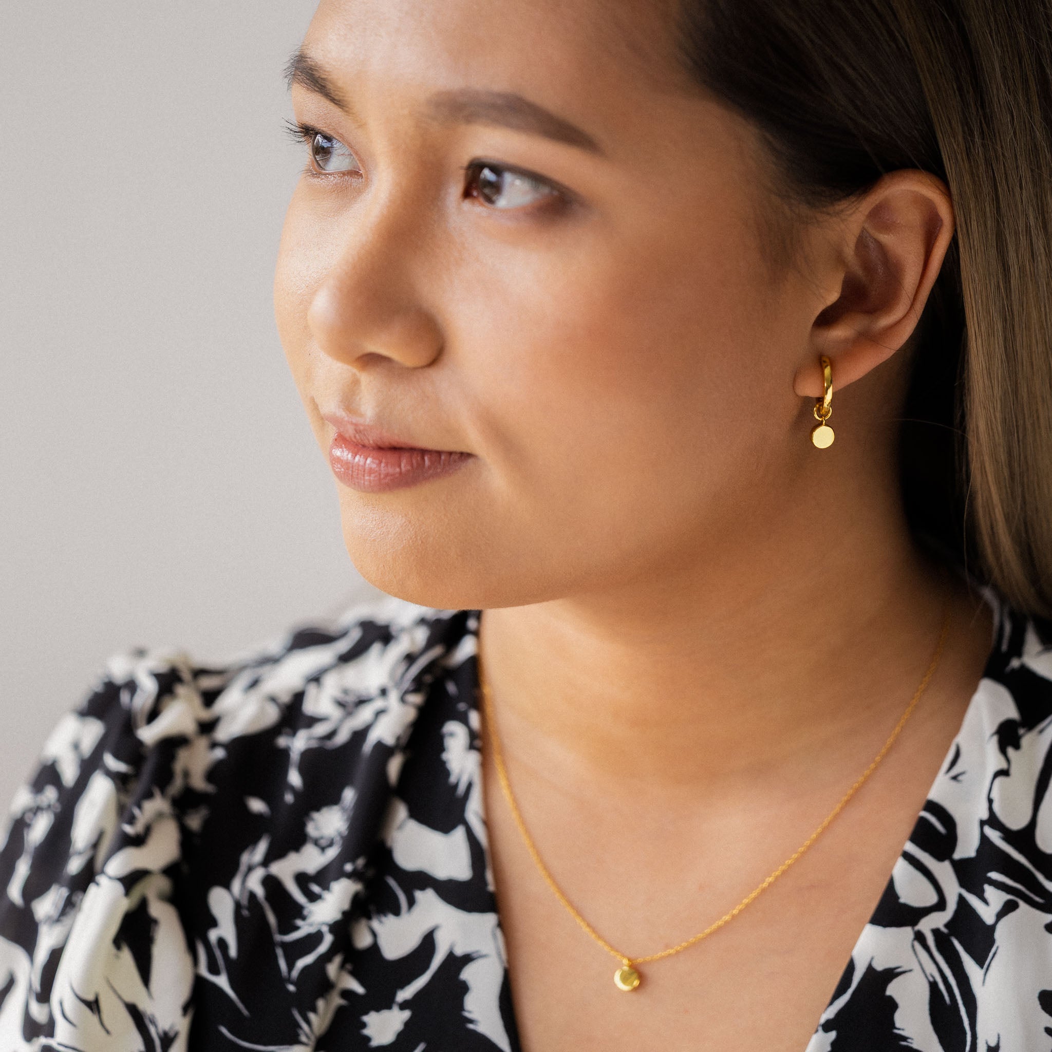 See Camille Malazo Dela Cruz radiating charm in BY TONIN's elegant gold hoop earrings with round disc charms, perfectly paired with a delicate round pendant necklace.
