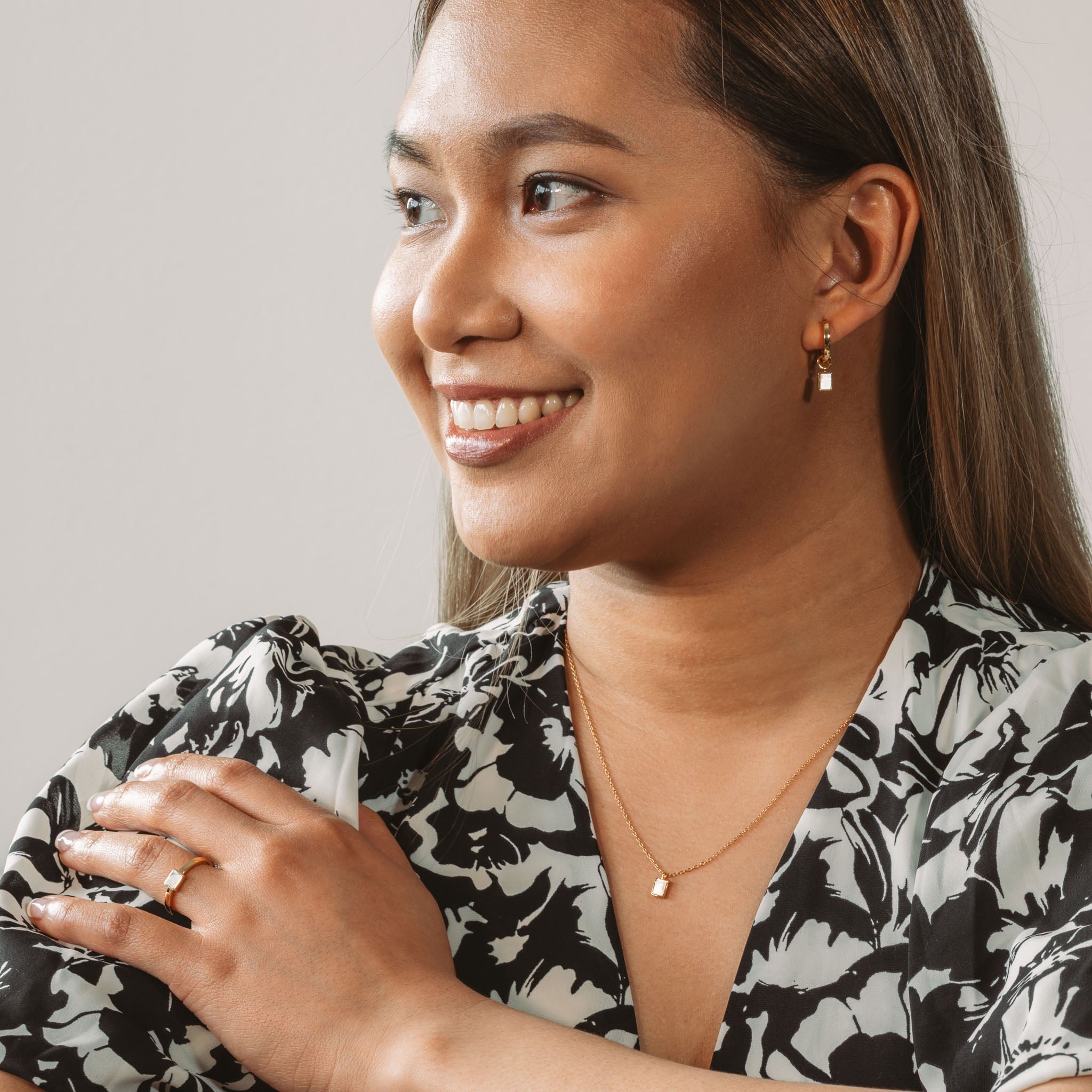 Witness Camille Malazo Dela Cruz radiating joy in BY TONIN's elegant gold jewelry collection, perfectly complementing her chic black and white floral dress.