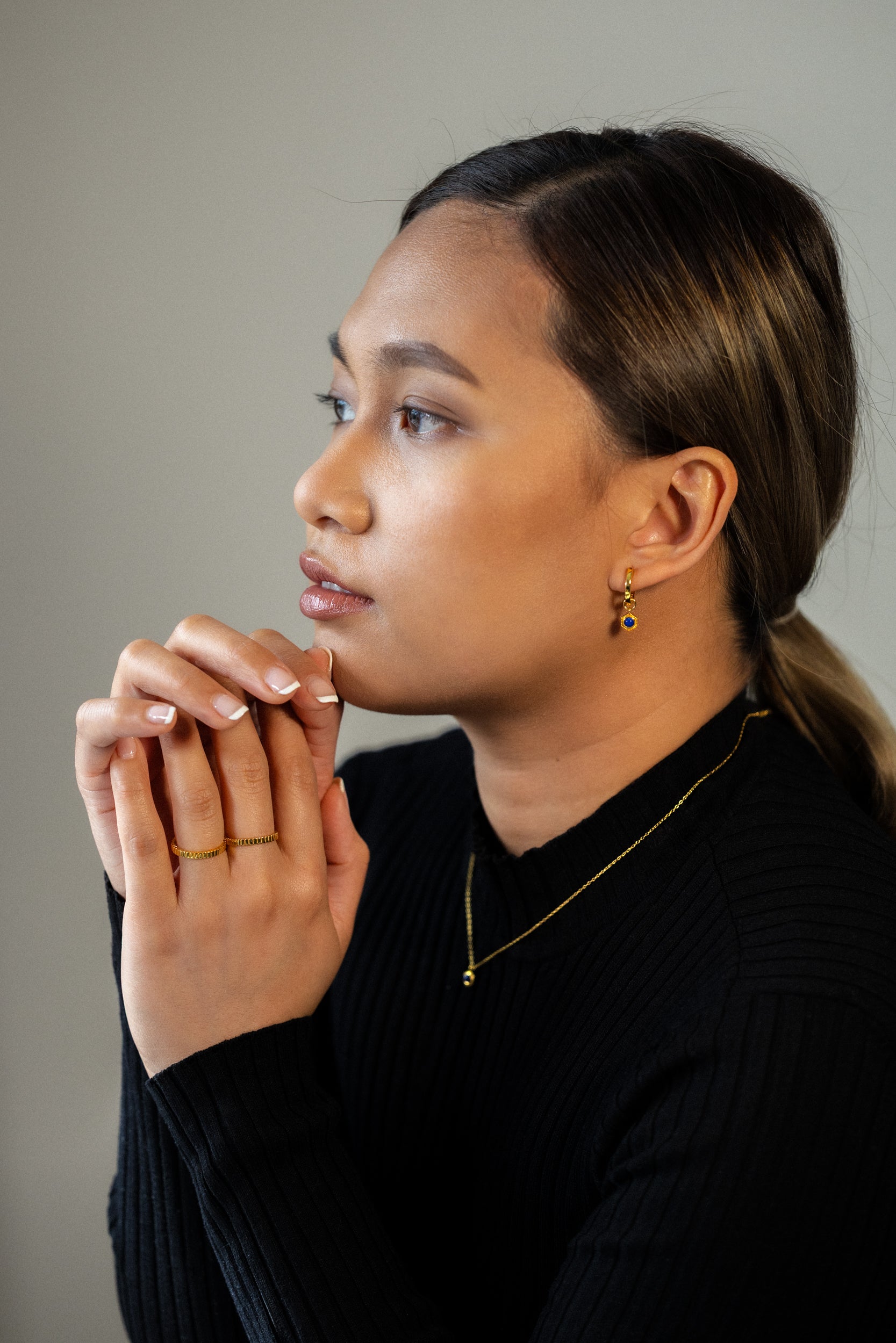 Discover BY TONIN's radiant gold jewelry collection, beautifully showcased by Camille Malazo Dela Cruz wearing elegant gold stud earrings, stacking rings, and a delicate gold necklace.