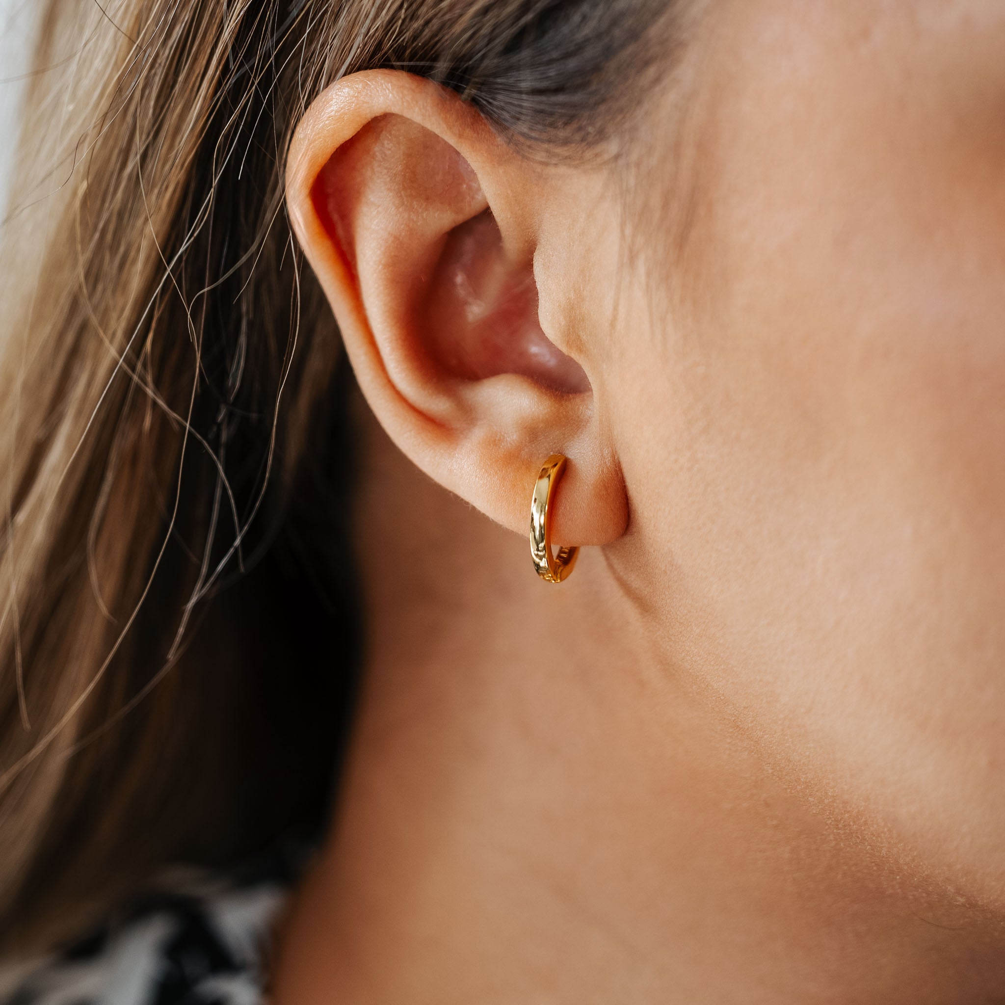 Experience understated elegance with BY TONIN's Heritage gold mini hoop earring, gracefully worn and highlighted in a beautiful close-up, perfect for versatile everyday style.