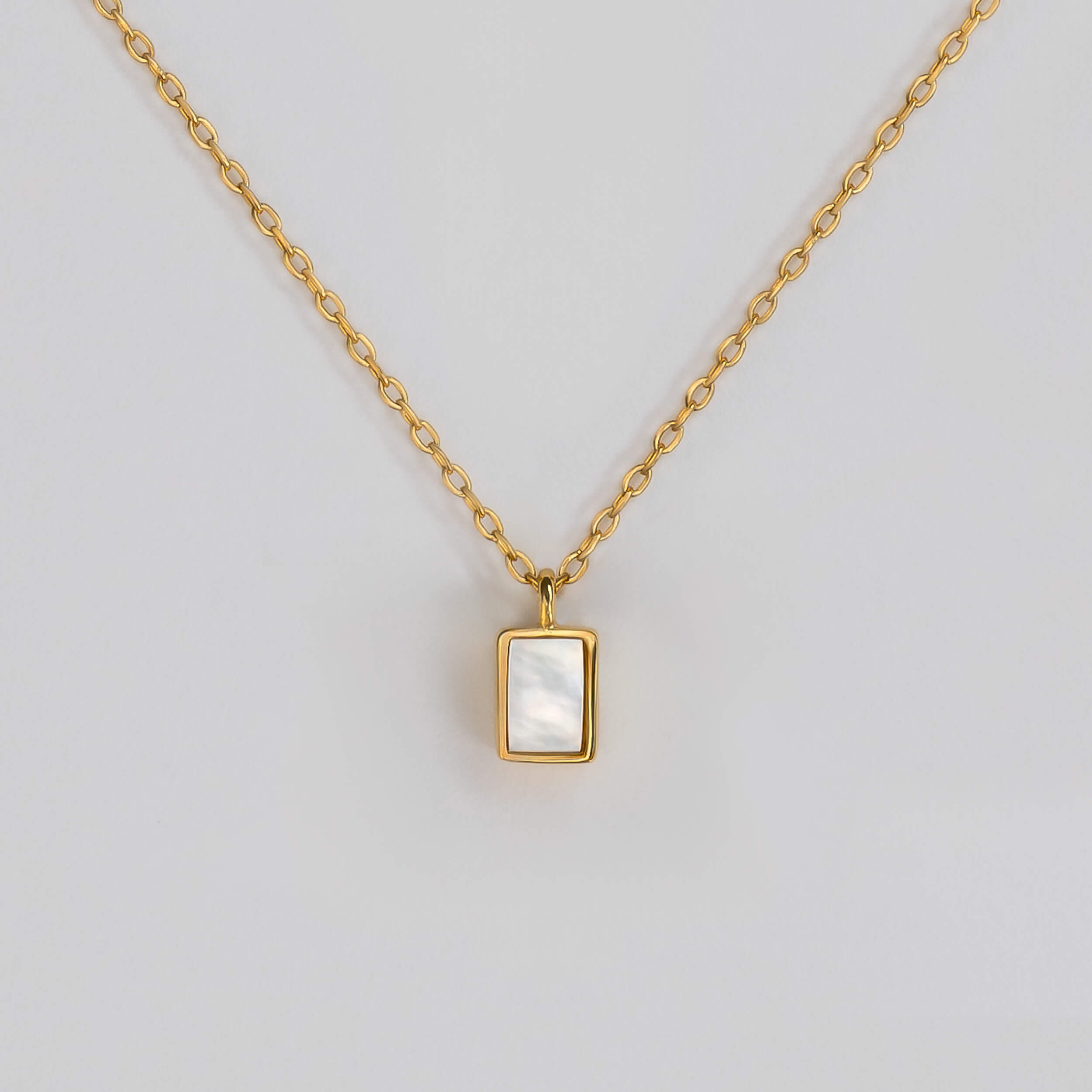 BY TONIN Heritage gold necklace with a rectangular mother of pearl pendant, showcasing its elegant design.
