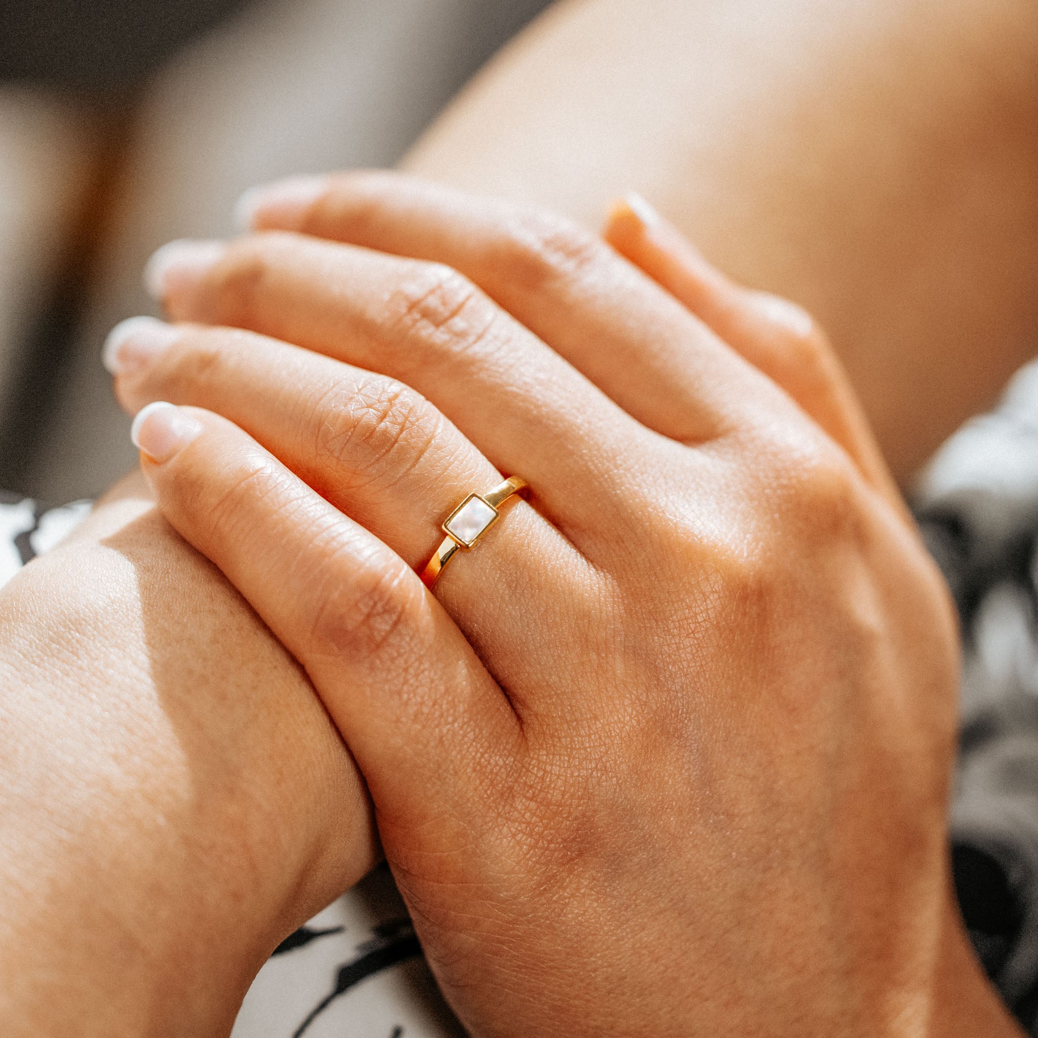 Adorn your fingers with BY TONIN's Heritage gold ring, showcasing a luminous rectangular mother of pearl centerpiece in a beautiful close-up on a hand, epitomizing elegant simplicity.