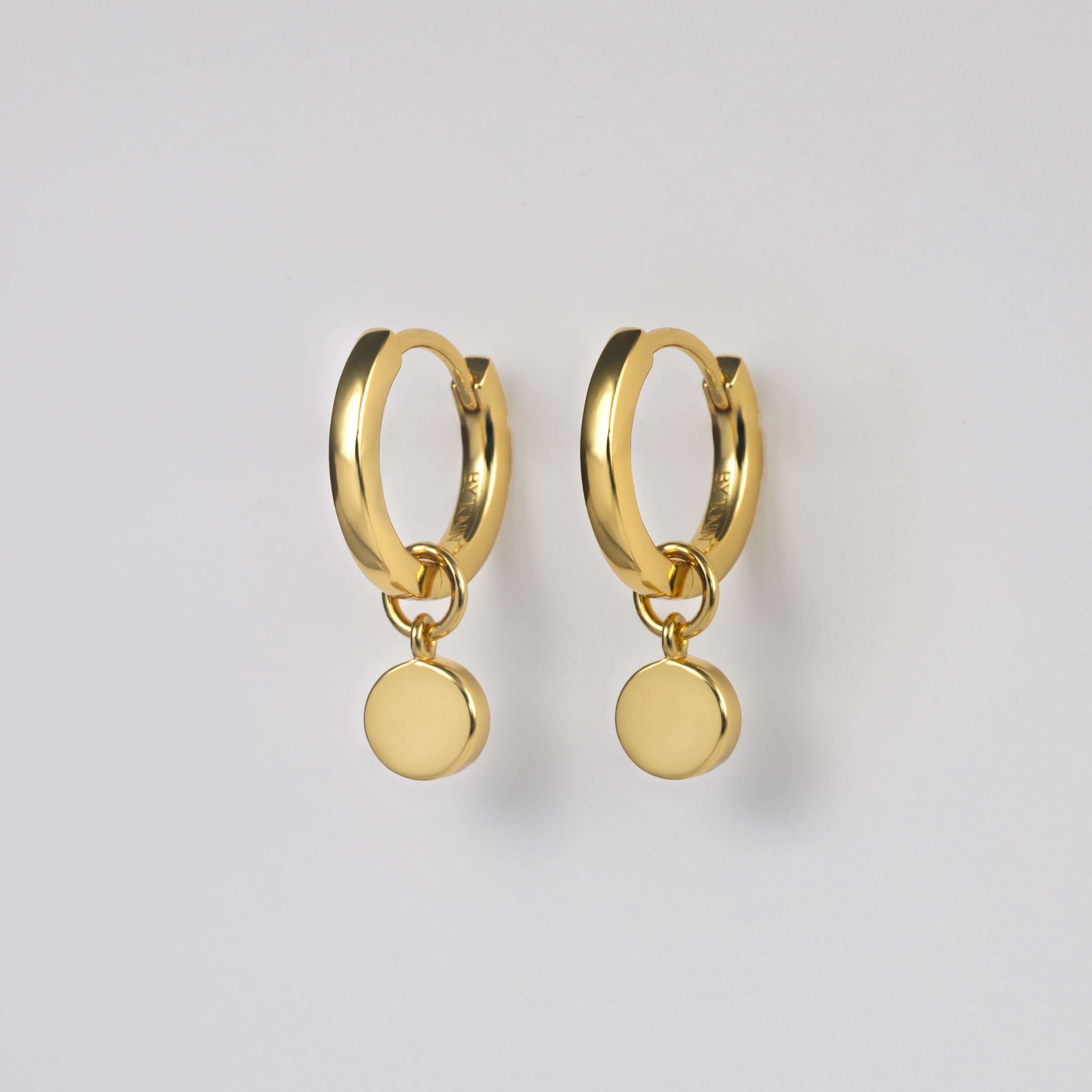 BY TONIN Heritage collection, classic gold round hoop earrings with drop circle charm.