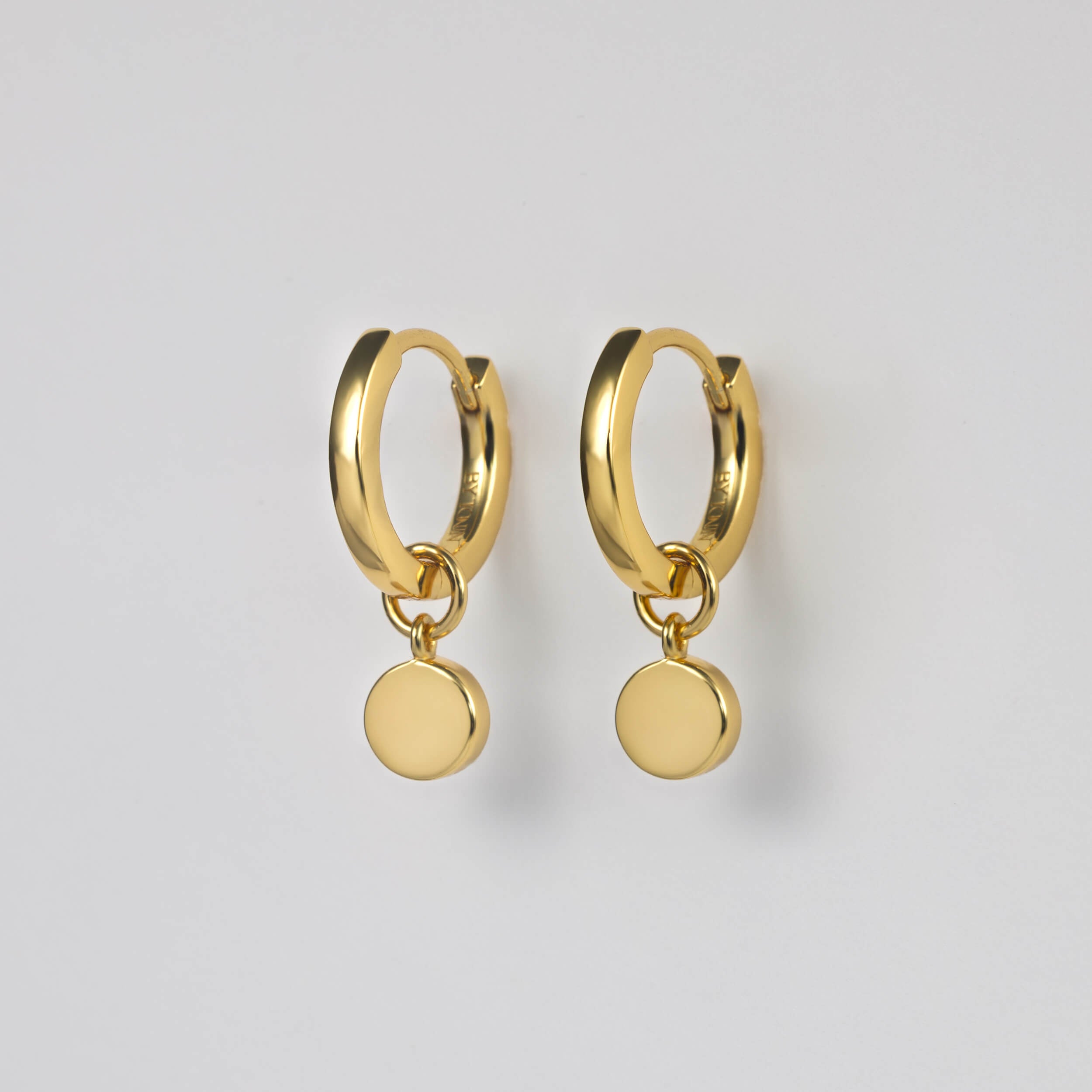 BY TONIN Heritage collection, classic gold round hoop earrings with drop circle charm.