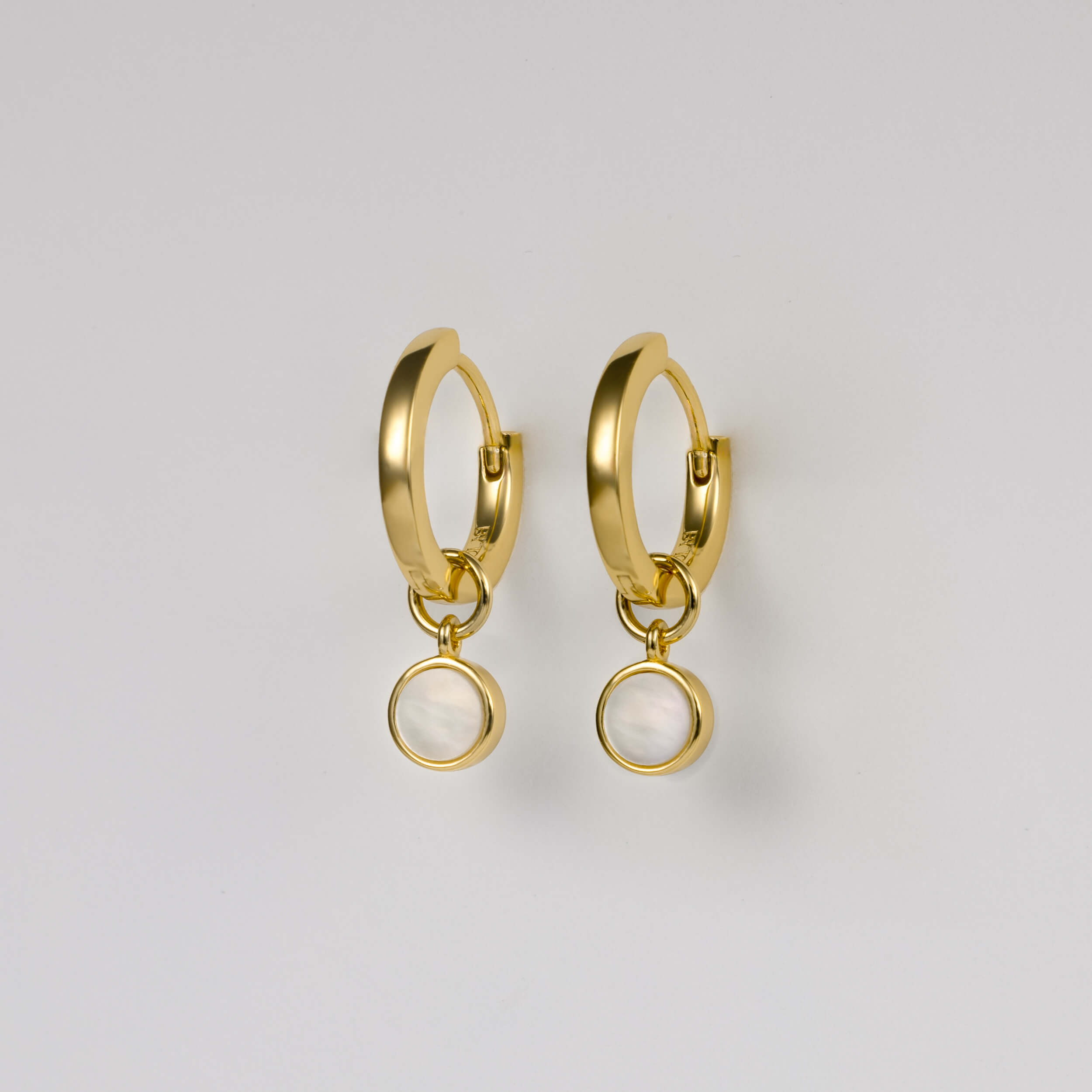BY TONIN Heritage gold round hoop earrings with luminous circular mother of pearl charms.
