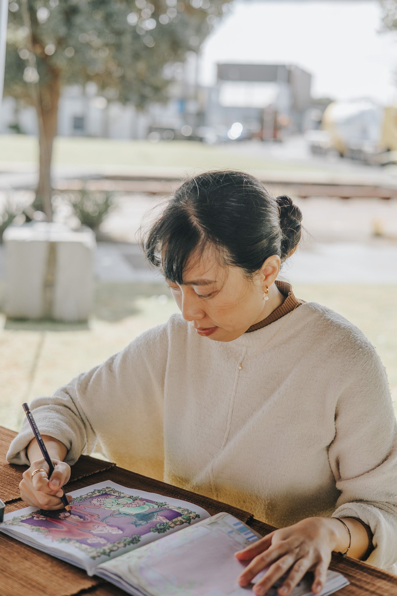 Woman drawing in a sketchbook outdoors