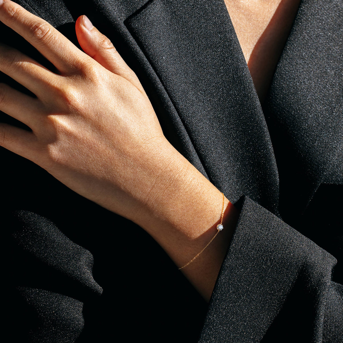 Contemporary styling of the BY TONIN Essential Diamond Bracelet contrasted against a structured black blazer, illustrating how modern minimalist jewellery transitions from day to evening wear.