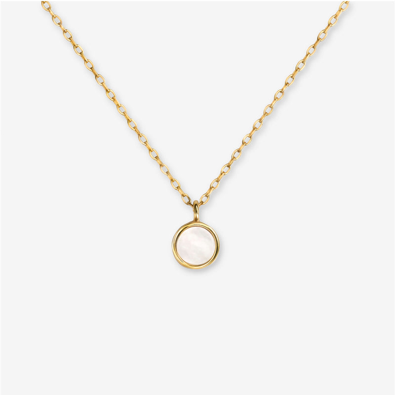 BY TONIN Heritage gold necklace with a luminous round mother of pearl pendant on white background.
