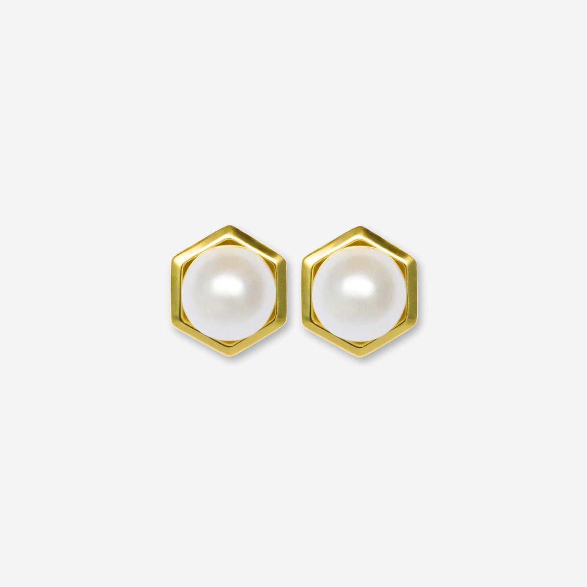 Hexagonal gold earrings with pearl centers on a white background
