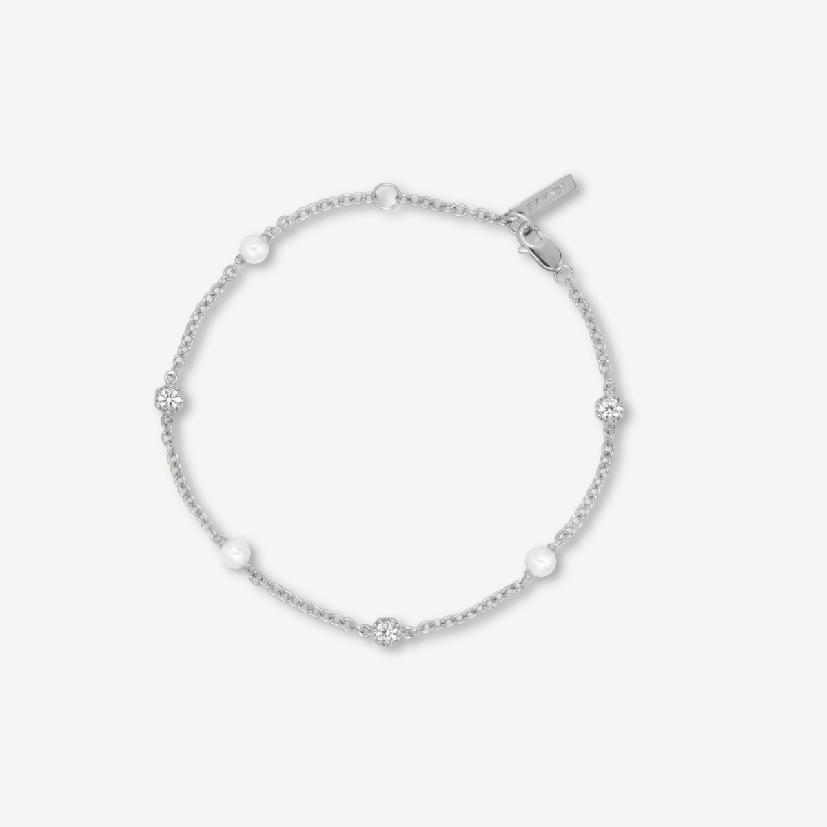 Silver bracelet with small pearls and topaz on a light background