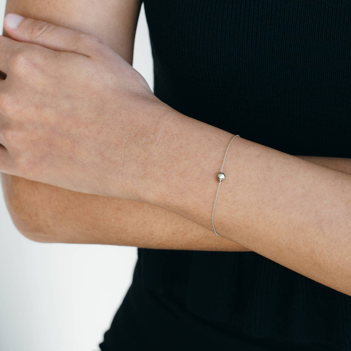 BY TONIN 925 sterling silver diamond bracelet back view against a black top. A study in modern minimalism and clean lines, perfect for contemporary silver jewellery collections.