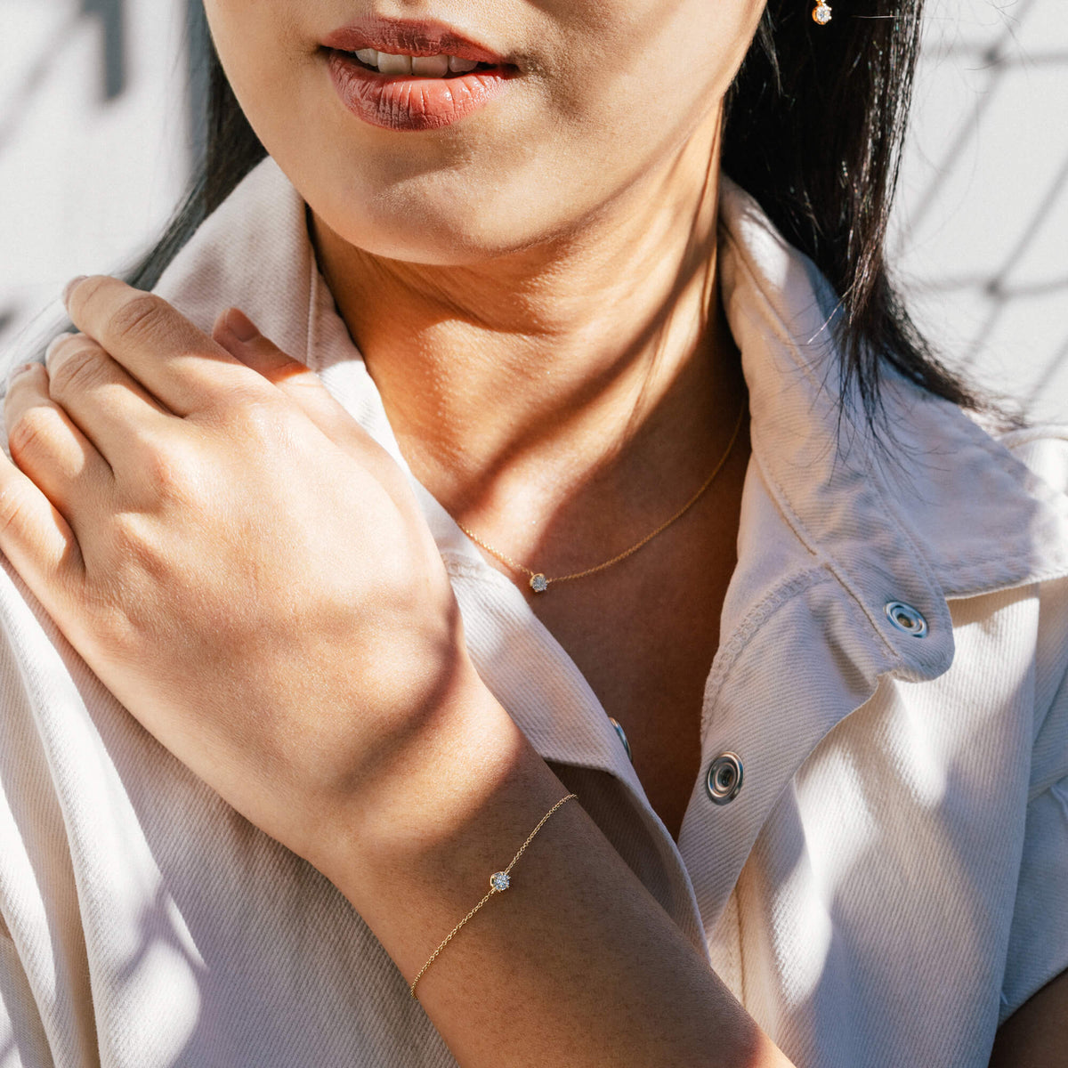 Studio lifestyle portrait of a model wearing the BY TONIN gold diamond bracelet paired with a casual white demin shirt, demonstrating effortless everyday styling and modern jewellery gifting inspiration.