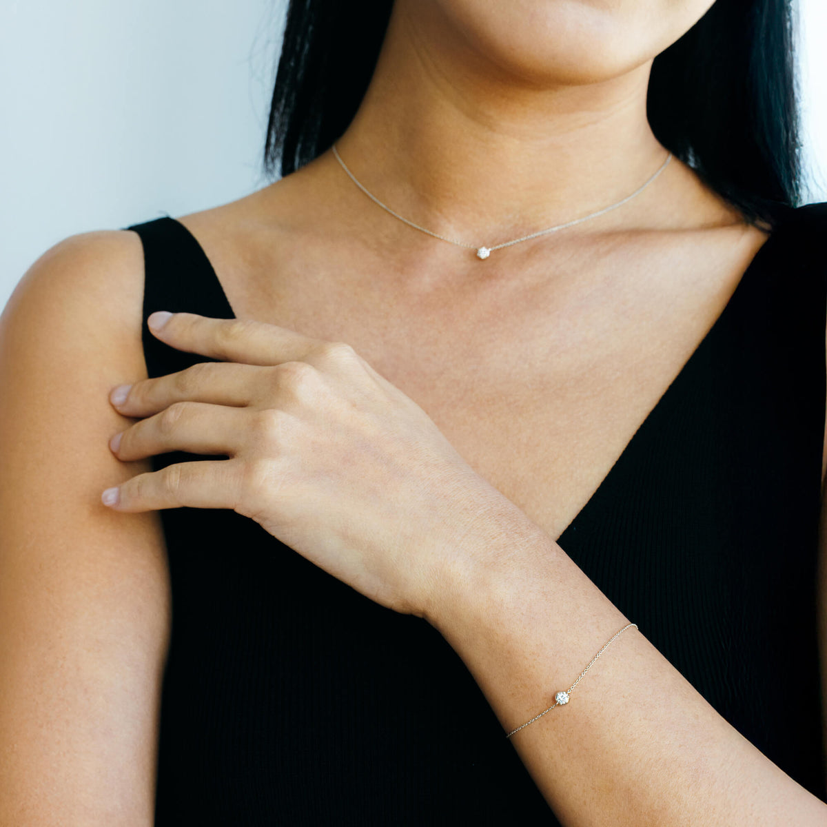 A portrait and neckline view showing a model wearing the BY TONIN 925 sterling silver diamond chain bracelet paired with a matching delicate silver pendant necklace, illustrating a complete minimalist everyday jewellery set.