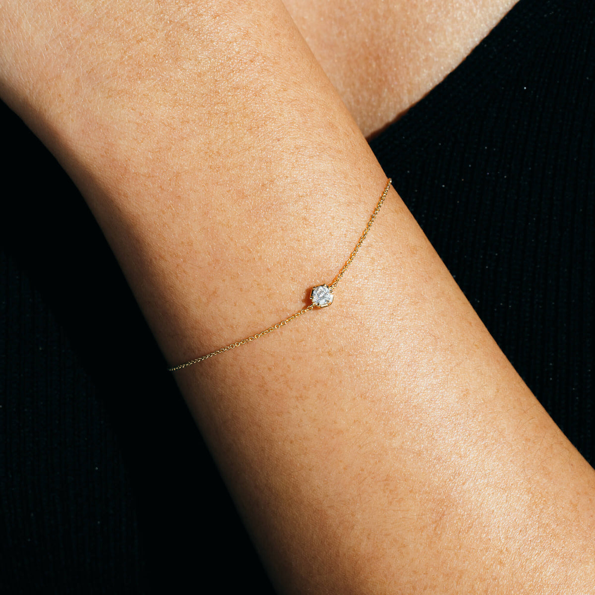 Close-up view of the BY TONIN Essential Diamonds Bracelet on a wrist, showcasing the solitary 0.2 ct lab-grown diamond on a delicate 9K gold chain. A minimalist piece designed for everyday wear New Zealand.