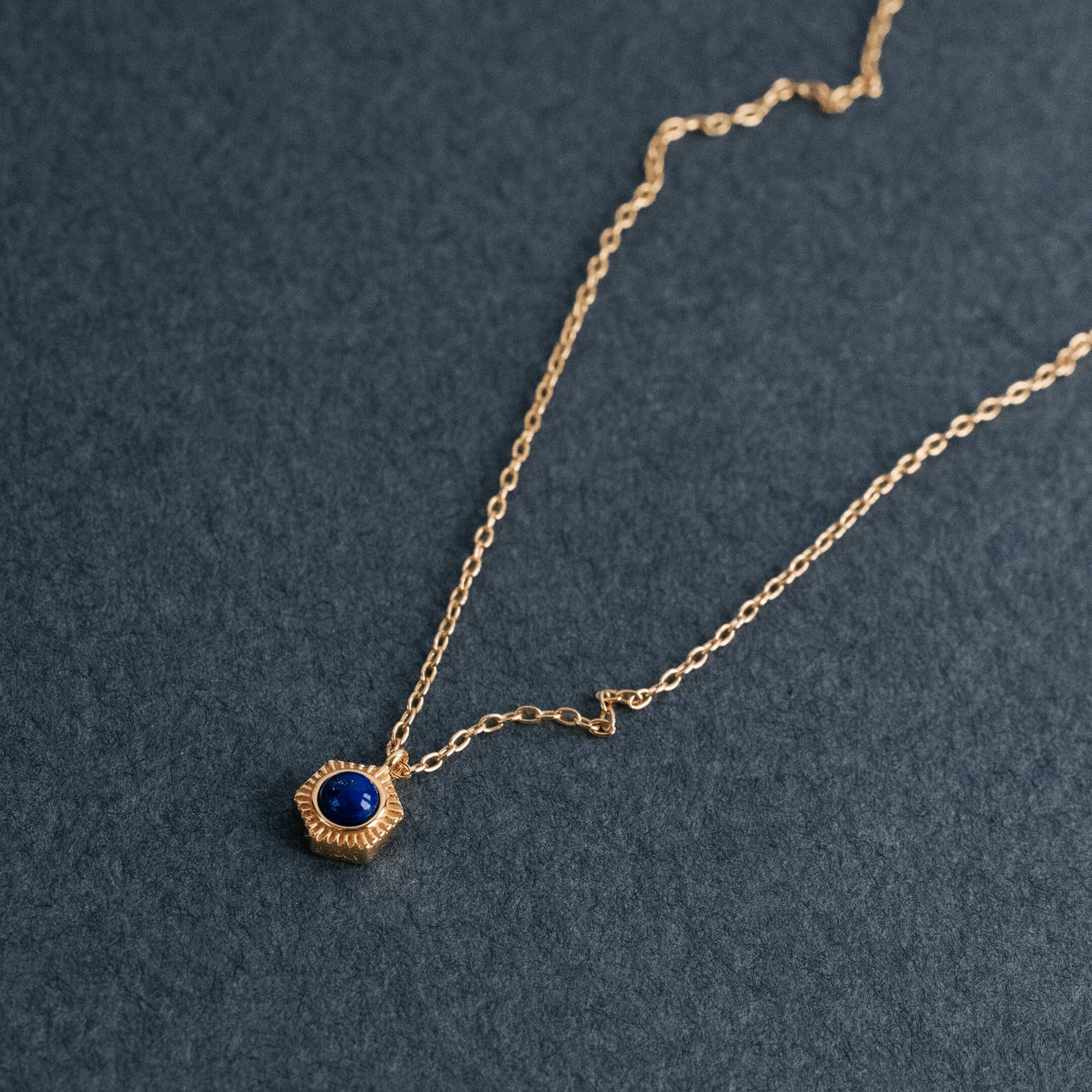 Necklace - Close-up of the Gold Lapis Lazuli pendant with Honeycomb/Hexagonal motif on a dark background.