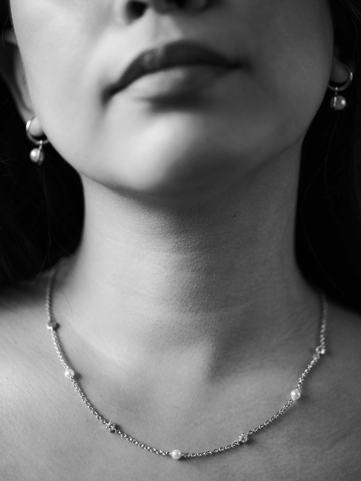 Close-up of a person wearing a delicate necklace with Topaz and Pearls