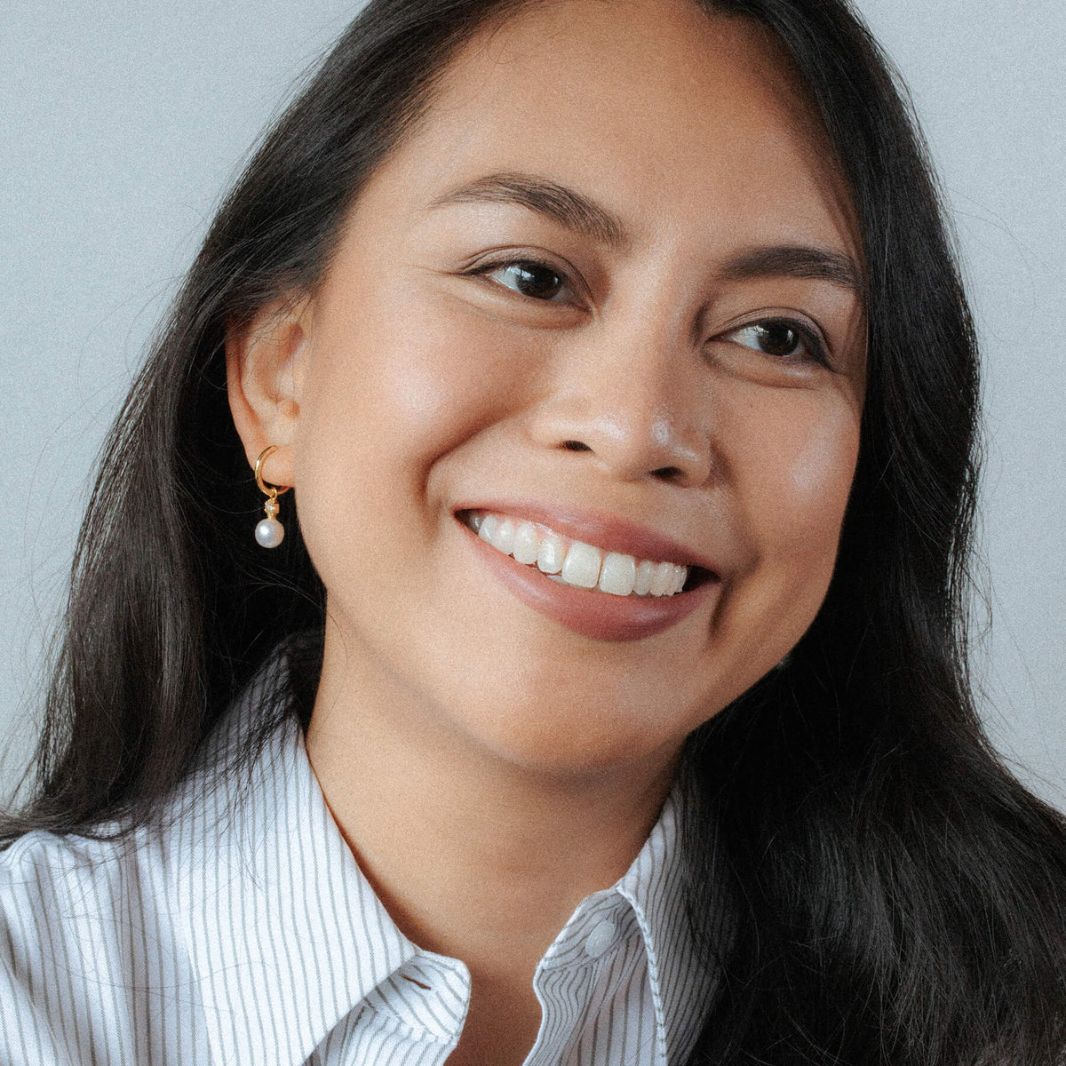 Mia Tonin wearing La Clara Round Pearl Earrings on a gray background