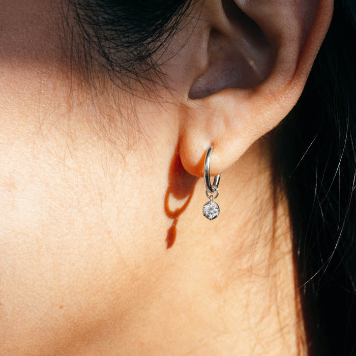 Macro profile view of the BY TONIN Essential Diamonds Drop Hoop Earrings in 925 sterling silver, showing a single 0.2 carat brilliant-cut lab diamond charm hanging from a fine silver hoop. Designed in NZ for intentional daily wear