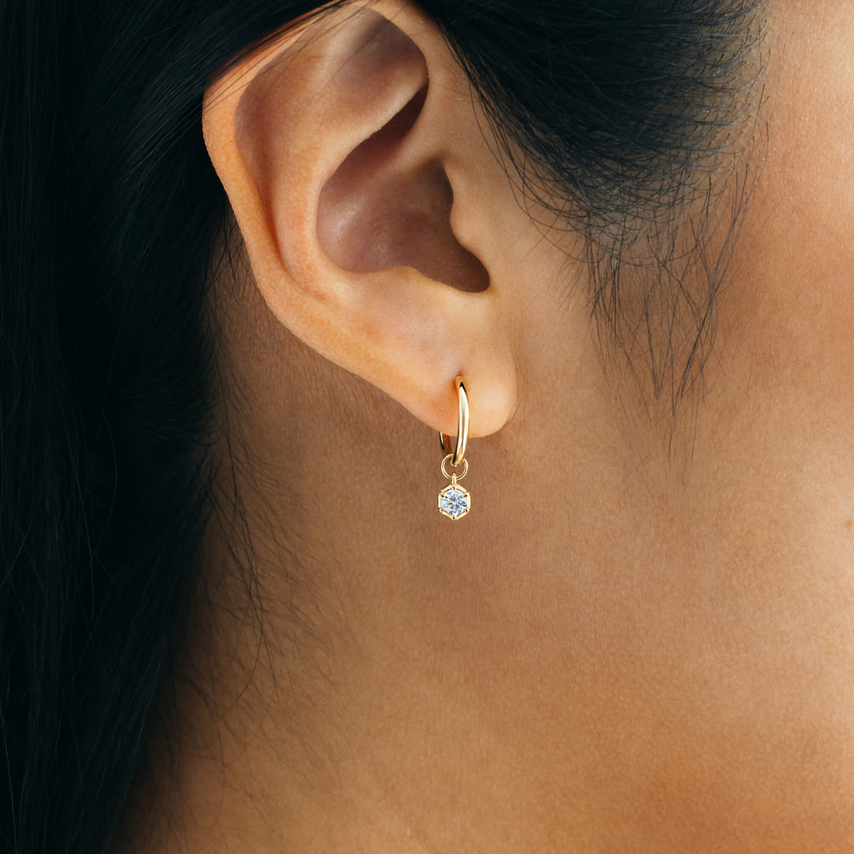 Macro profile view of the BY TONIN Essential Diamonds Drop Hoop Earrings in 9K gold, showing a single 0.2 carat brilliant-cut lab diamond charm dangling from a small fine gold hoop