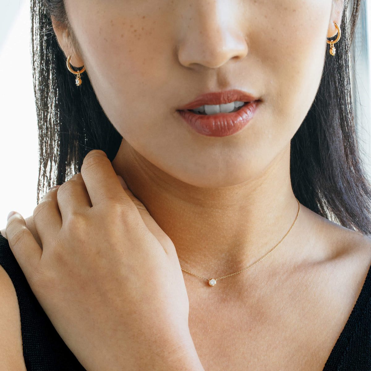 On-model shot featuring the 9K gold fine pendant necklace paired with matching lab-grown diamond drop hoop earrings from the Essential Diamond Collection by BY TONIN, demonstrating coordinated minimalist jewelry styling.
