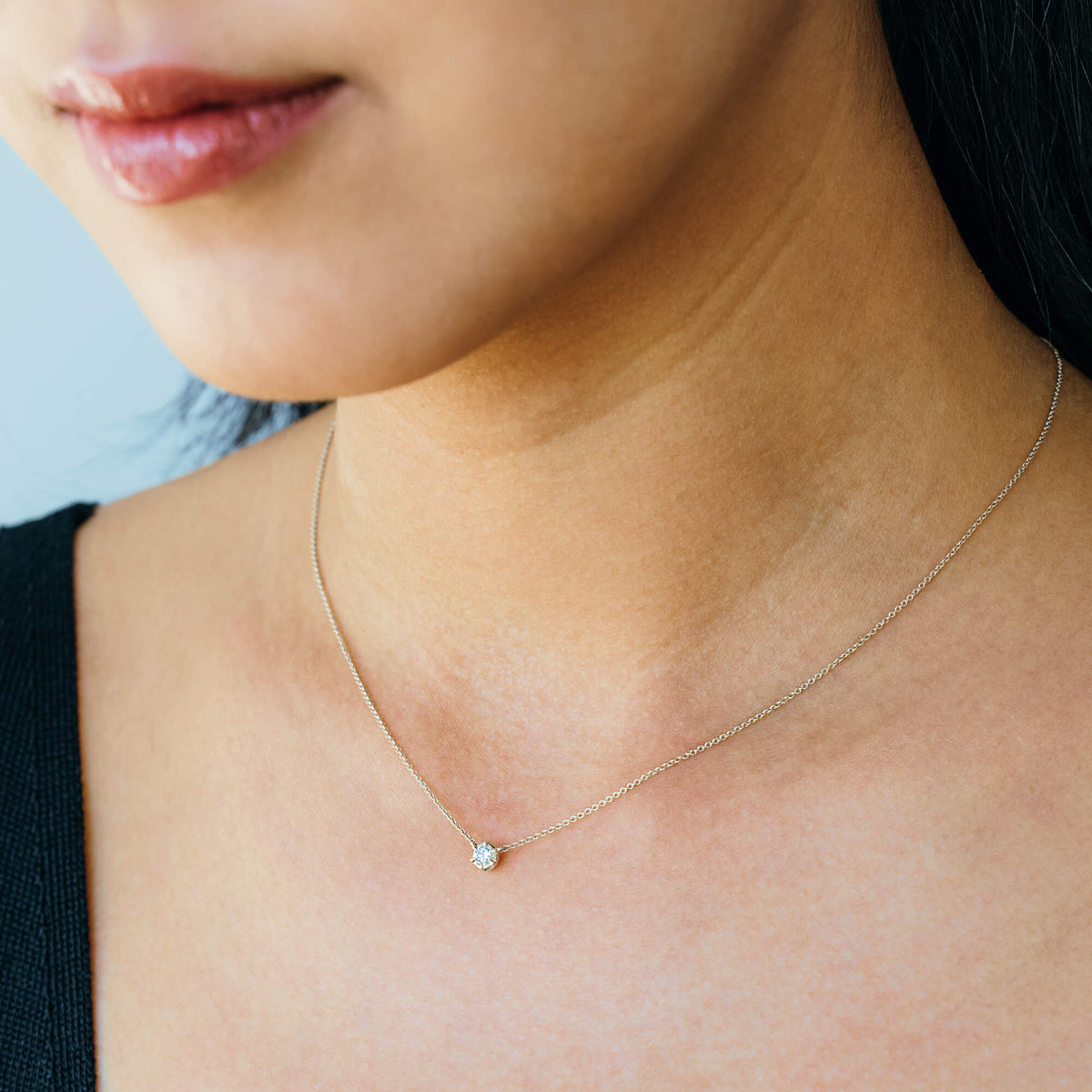 On-model perspective of the BY TONIN silver pendant necklace, highlighting the clear contrast of the brilliant-cut 0.2 carat lab diamond charm and refined 925 sterling silver hardware against a black top.