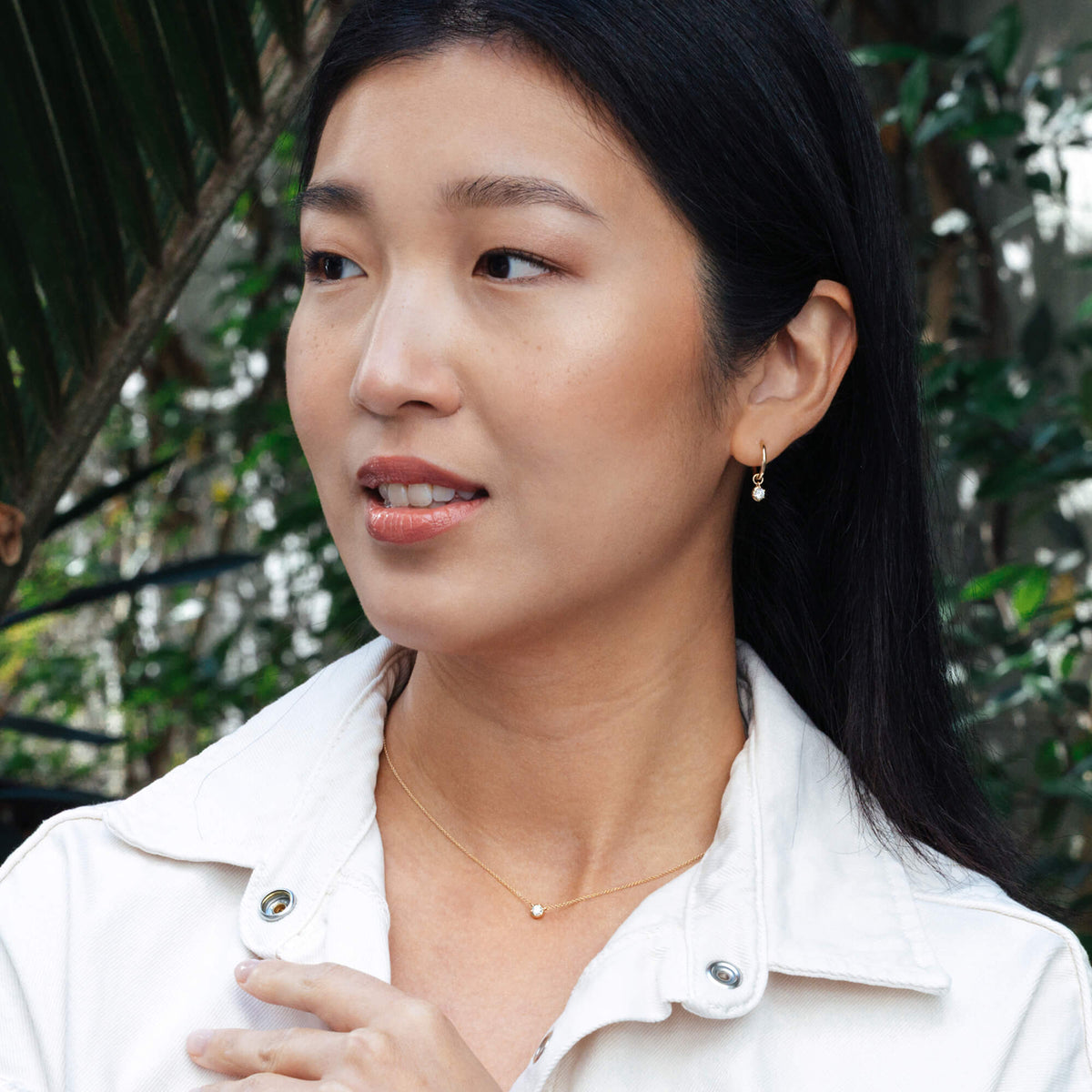 Outdoor lifestyle view of a model Hye Won Jang styling the BY TONIN 9K gold diamond hoop earrings with a casual white shirt, serving as an aesthetic reference for intentional modern jewellery gifting in New Zealand.