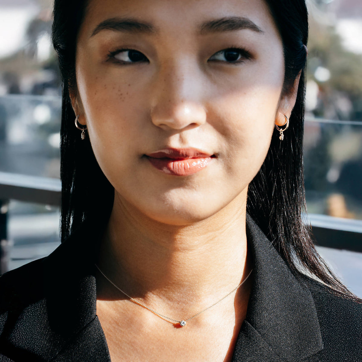 Studio view of a model styling the BY TONIN silver diamond drop earrings with a structured black blazer, illustrating contemporary wardrobe transitions and intentional modern jewellery for professional dressing.