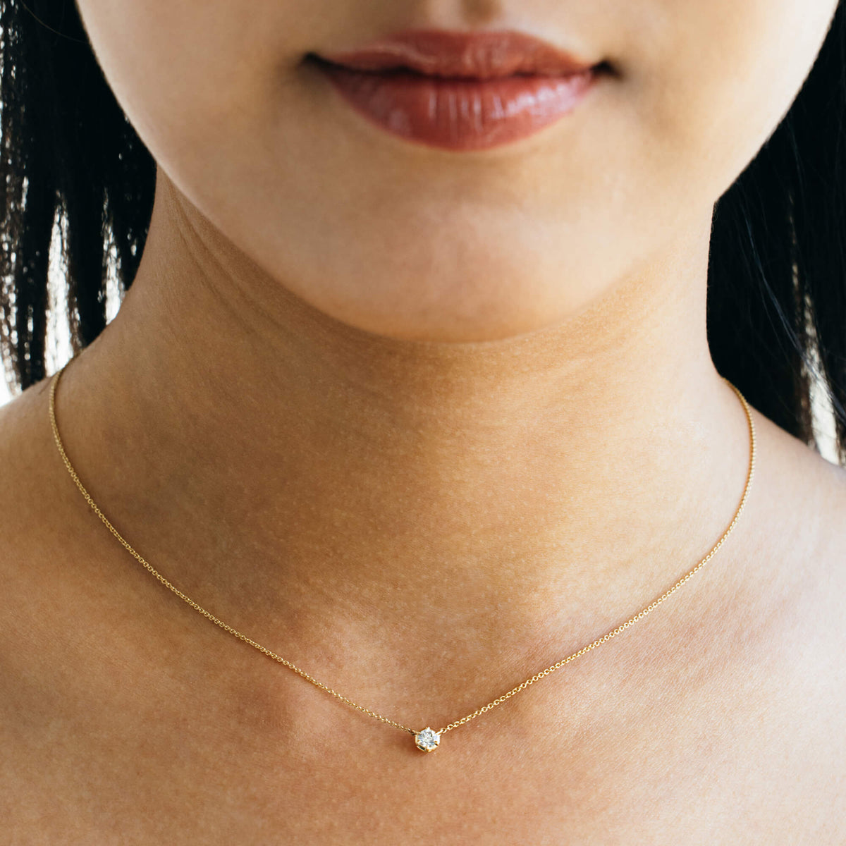 Close-up on-model view of the 9K gold fine chain pendant necklace from the Essential Diamond Collection by BY TONIN, designed in NZ. Displays a brilliant-cut 0.2 ct lab-grown diamond sitting gracefully on the collarbone.